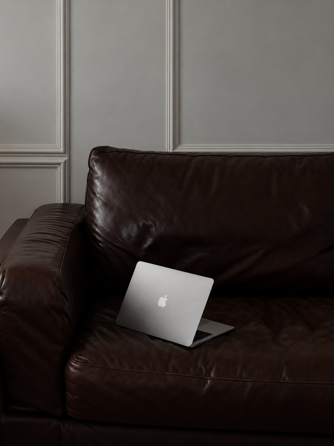 Univers du studio Compü : ordinateur portable sur un canapé en cuir